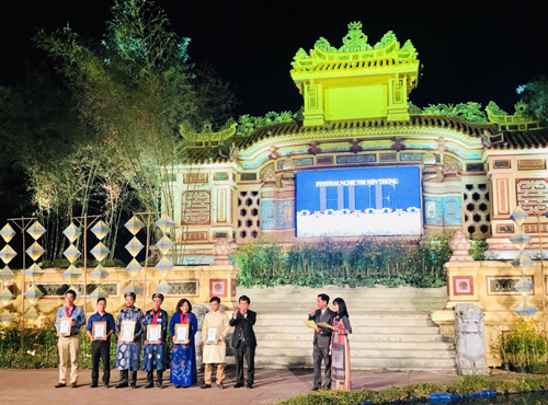 Nghệ nhân Nguyễn Văn Hưng nhận giải Nhất tại Festival Nghề Truyền thống tại Huế với tuyệt phẩm Đôi Bảo Bình màu lam Sơn Thủy hữu tình. (Người đứng thứ ba từ trái sang)