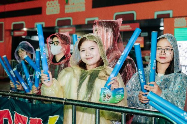 Nhìn lại những khoảnh khắc thăng hoa của dàn sao trong đêm nhạc VPBank Prime Night- Ảnh 7. A group of people wearing raincoats holding blue tubes  AI-generated content may be incorrect.