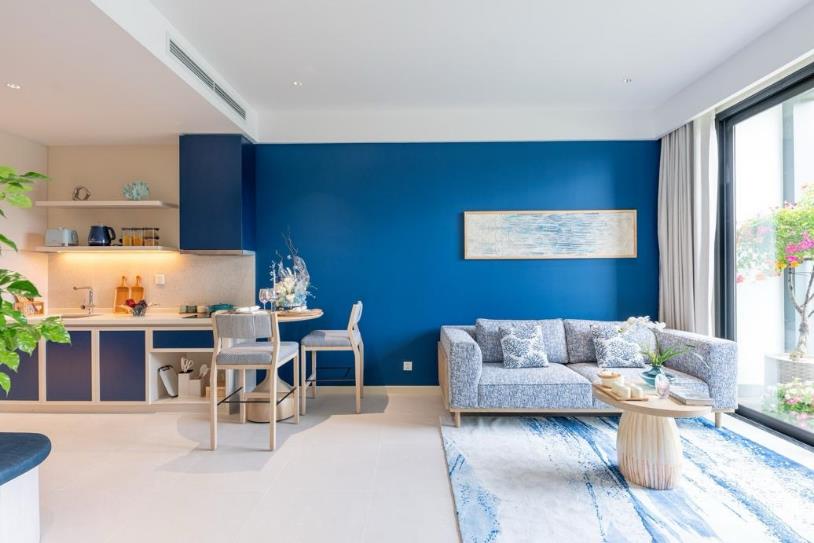 A living room with a blue wall and a couch  AI-generated content may be incorrect.