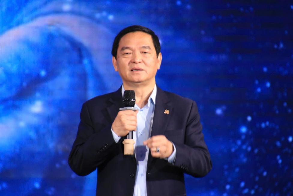 A person in a suit holding a microphone  AI-generated content may be incorrect.