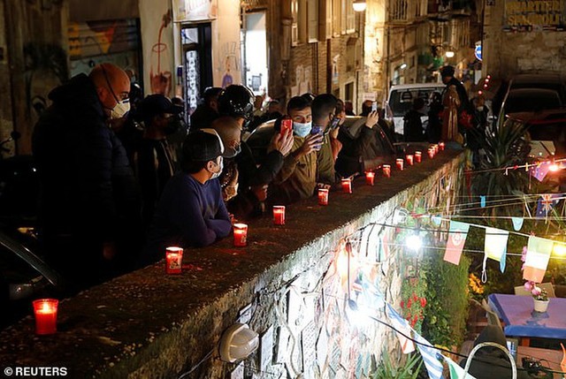 Người dân thành phố Napoli đeo khẩu trang đổ xô ra đường để chia buồn khi nghe tin cậu bé vàng qua đời. Ảnh: Reuters.
