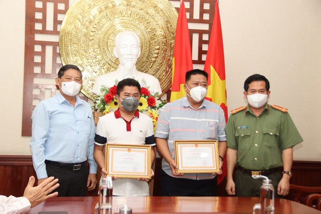 Ông Lưu Vĩnh Nguyên, Trưởng Ban Nội chính Tỉnh ủy (trái) và Đại tá Đinh Văn Nơi, Giám đốc Công an tỉnh trao Giấy khen Công an tỉnh cho các Nhà hảo tâm.