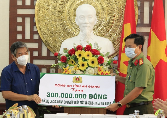 Đại tá Nguyễn Nhật Trường - Phó Giám đốc Công an tỉnh trao bảng tượng trưng hỗ trợ tiền cho Đại diện Mặt trận Tổ quốc Việt Nam tỉnh.