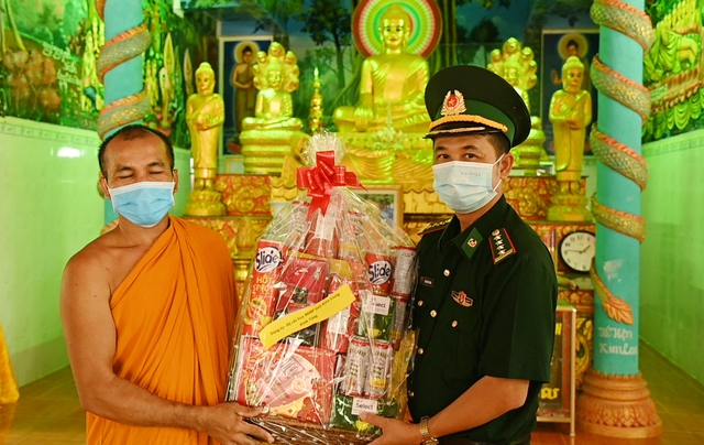 Phó Chính ủy Bộ đội Biên phòng tỉnh Kiên Giang trao quà cho trụ trì chùa Giồng Kè, huyện Giang Thành.