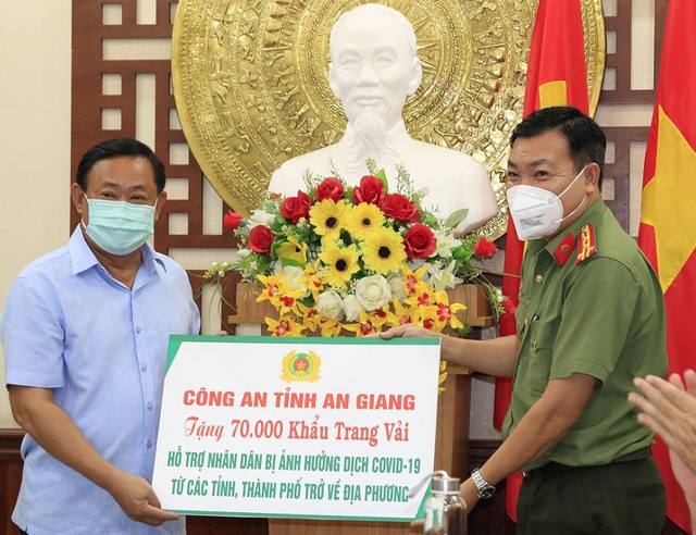Đại tá Lâm Thành Sol, Phó Giám đốc Công an tỉnh An Giang trao bảng tượng trưng tặng 70.000 khẩu trang vải cho Ủy ban MTTQ tỉnh gửi đến nhân dân.