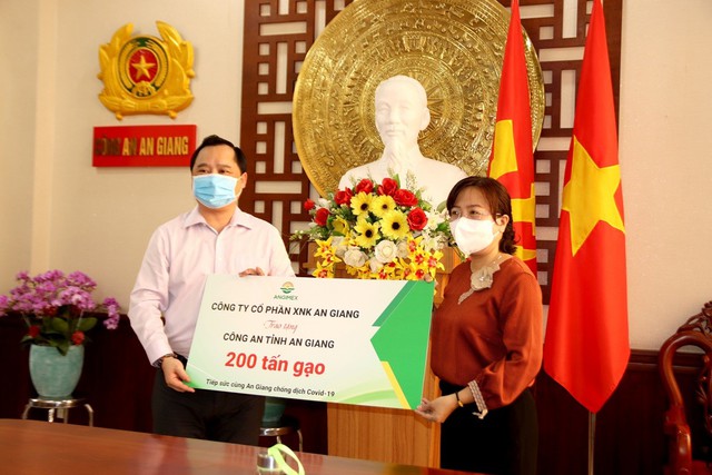 Bà Nguyễn Thị Tuyết Minh, Phó chủ tịch UBMTTQ tỉnh An Giang nhận bảng tượng trưng 200 tấn gạo từ ông Đỗ Thành Nhân, Chủ tịch HĐQT Công ty cổ phần xuất nhập khẩu An Giang - ANGIMEX.