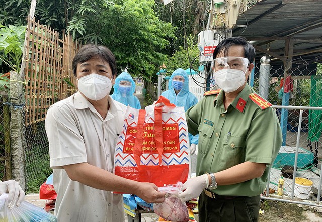 Đại tá Nguyễn Nhật Trường, Phó Giám đốc Công an tỉnh thăm, tặng quà cho các hộ dân trong khu vực phong tỏa ở phường Mỹ Thạnh.