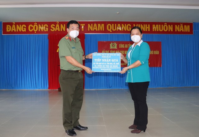 Đại tá Lâm Thành Sol, Phó Giám đốc Công an tỉnh An Giang trao bảng tiếp nhận quà cho đại diện lãnh đạo huyện Cầu Kè, tỉnh Trà Vinh.