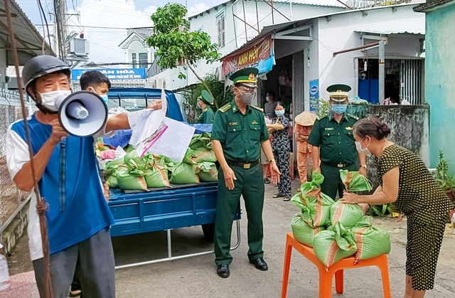 Đại tá Doãn Đình Tránh - Phó Chính ủy Bộ đội Biên phòng tỉnh Kiên Giang trao các phần quà cho người dân gặp khó khăn trên địa bàn TP Rạch Giá.