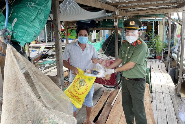 Đại tá Lâm Thành Sol, Phó Giám đốc Công an tỉnh tặng gạo và nhu yếu phẩm cho bà con nhân dân làng bè xã Khánh An, huyện An Phú.