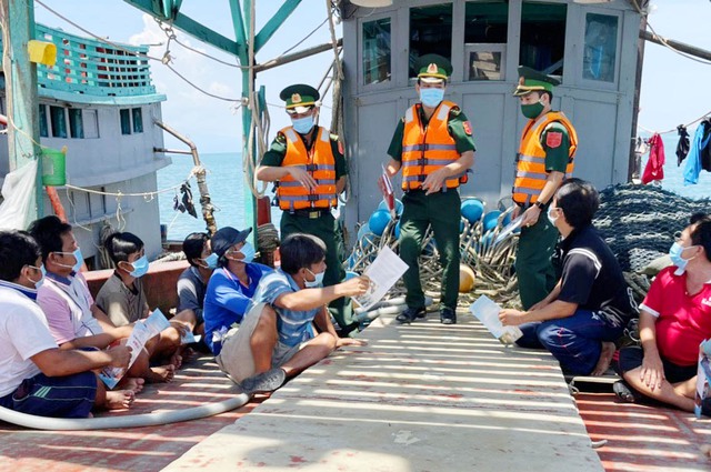 Bộ đội Biên phòng tỉnh Kiên Giang tuyên truyền cho ngư dân không vi phạm chủ quyền vùng biển nước ngoài và trao cờ, ảnh Bác động viên bà con ra khơi an toàn, đúng pháp luật.