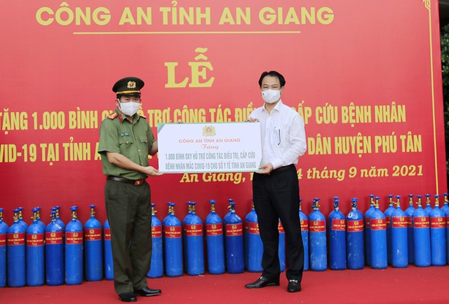 Đại tá Đinh Văn Nơi, Giám đốc Công an tỉnh trao Bảng tượng trưng tặng 1.000 bình oxy cho Giám đốc Sở Y tế - Trần Quang Hiền.