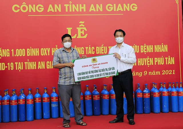 Ông Trần Quang Hiền - Giám đốc Sở Y tế An Giang nhận Bảng tượng trưng tặng 1.000 bình oxy từ ông Trần Đông Xuân - Giám đốc Công ty Cổ phần đầu tư xây dựng Tấn Thắng.