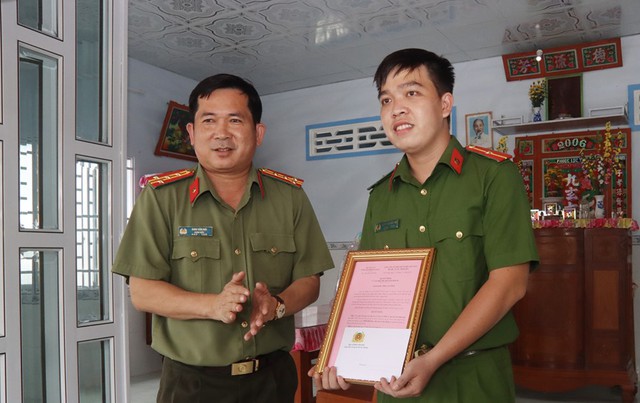 Đại tá Đinh Văn Nơi - Giám đốc Công an tỉnh (bìa trái) chúc mừng Thiếu úy Nguyễn Phan Nhật Linh có được ngôi nhà mới.