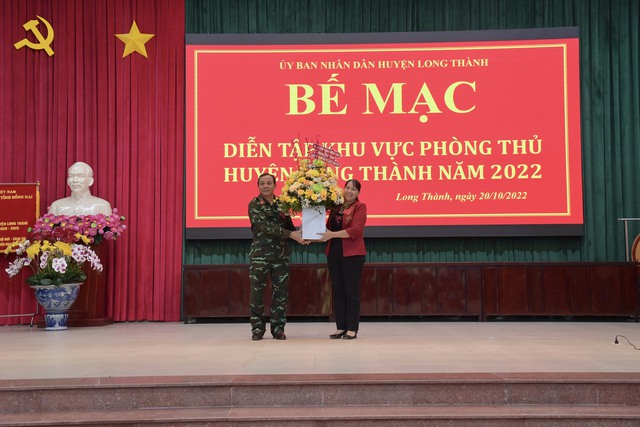Các nữ đại biểu tham dự Diễn tập Khu vực phòng thủ huyện Long Thành bất ngờ nhận được hoa chúc mừng 20/10 từ các lãnh đạo.