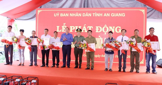 Ông Nguyễn Thanh Bình - Chủ tịch UBND tỉnh và Đại tá Lâm Phước Nguyên - Giám đốc Công an tỉnh trao Bằng khen của UBND tỉnh và hoa cho các cá nhân có thành tích xuất sắc trong phong trào toàn dân tham gia PCCC.