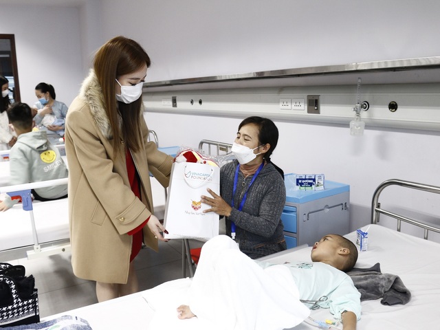 Chị Dee Trương, Tổng Giám đốc VITA Clinic tặng quà cho gia đình trẻ