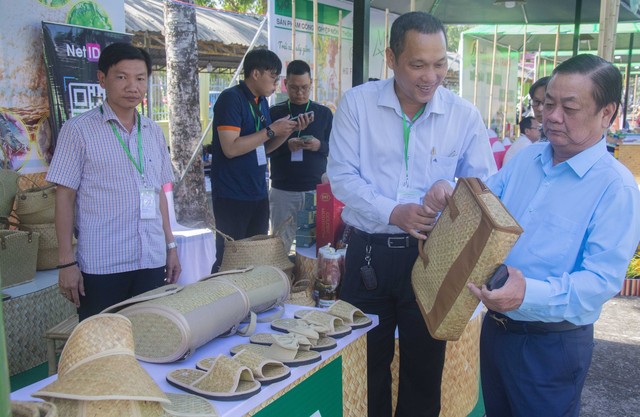Bộ trưởng Bộ Nông nghiệp và Phát triển Nông thôn tham quan gian hàng trưng bày sản phẩm được làm từ cỏ bàn của huyện Giang Thành, tỉnh Kiên Giang.