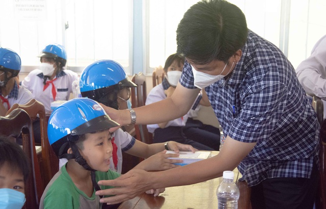 Ông Mai Minh Ngoan, Chánh Văn phòng Ban ATGT TP. Cần Thơ tặng nón bảo hiểm cho các em học sinh.