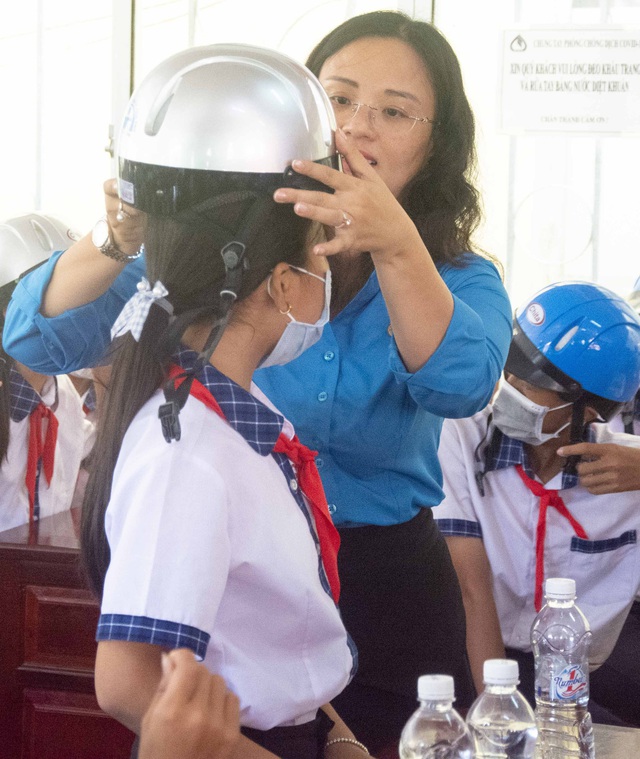 Bà Lê Thị Sương Mai, Chủ tịch LĐLĐ TP. Cần Thơ tặng nón bảo hiểm cho các em học sinh.