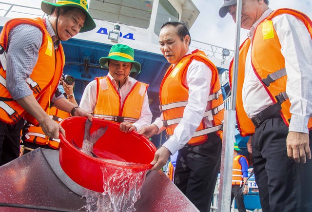 Thứ trưởng Bộ NN và PTNT, Phùng Đức Tiến cùng lãnh đạo Tổng cục Thủy sản, lãnh đạo tỉnh An Giang thả cá tái tạo nguồn lợi thủy sản xuống sông Hậu.