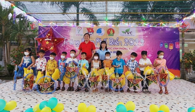 Ông Giang Văn Minh - Chủ nhiệm Câu lạc bộ Nét bút xanh Kiên Giang trao bánh trung thu và lồng đèn cho các em học sinh có hoàn cảnh khó khăn trường Tiểu học Vĩnh Phong 4.