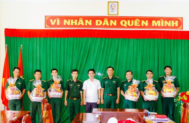 Ông Nguyễn Thanh Liêm - Chủ tịch UBND thị xã Vĩnh Châu (áo trắng đứng giữa) tặng quà cho cán bộ chiến sĩ là người dân tộc Khmer đang công tác tại đồn Biên phòng Lai Hòa.