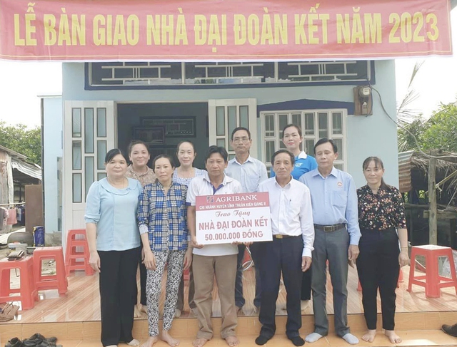 Các đại biểu chia sẻ niềm vui với gia đình anh Trần Văn Út và chị Lâm Thị Thiêu có nhà mới khang trang, kiên cố tại buổi trao nhà Đại đoàn kết.
