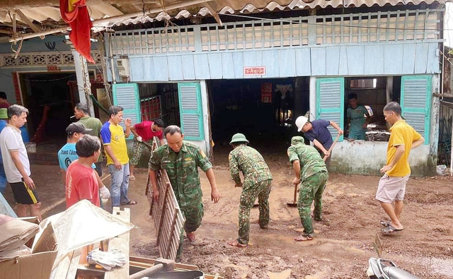 Cán bộ, chiến sĩ Biên phòng giúp dân khắc phục hậu quả mưa lũ.