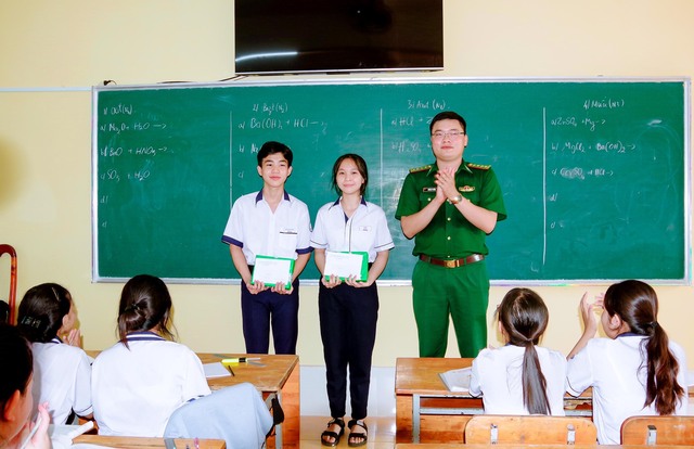 Đại úy Huỳnh Lý Tưởng, Chính trị viên đồn Biên phòng Trung Bình trao học bổng cho các em học sinh trong chương trình &quot;Nâng bước em tới trường&quot;.