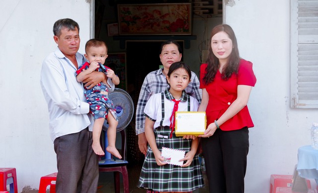 Đại diện lãnh đạo Hội liên hiệp phụ nữ huyện Trần Đề tặng quà cho cháu Nguyễn Đình.