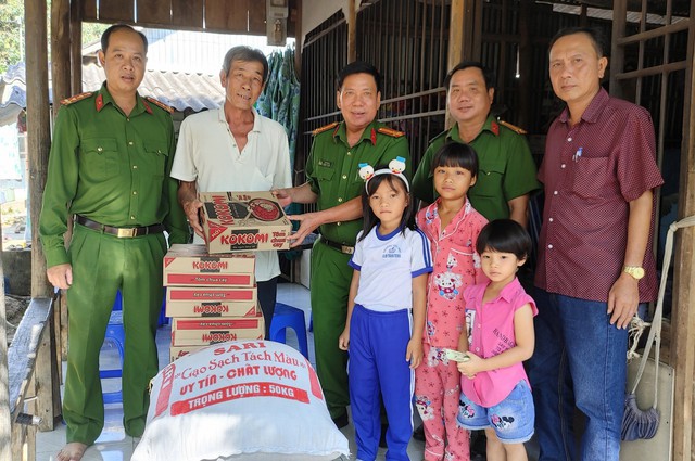 Thượng tá Lê Văn Đấu, Trưởng Công an huyện Chợ Mới trao quà cho gia đình và con của phạm nhân Ngô Thị Thơm.
