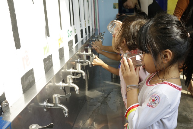 Các em học sinh uống nước lọc trực tiếp từ hệ thống lọc nước sạch