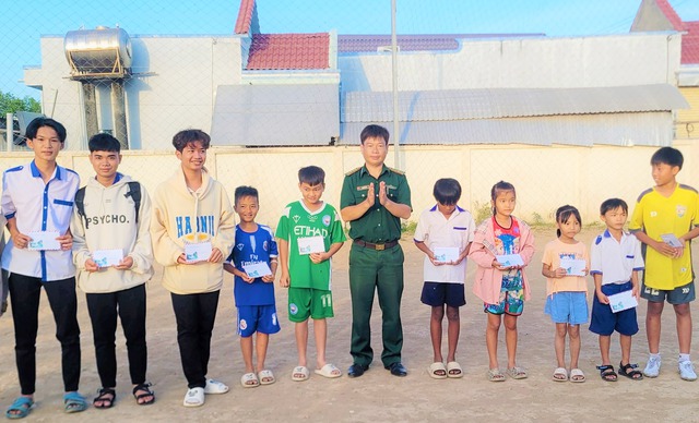 Đại úy Phạm Nam Sơn tặng quà cho các em học sinh trong Chương trình &quot;Nâng bước em đến trường - Con nuôi đồn biên phòng&quot; đơn vị nhận đỡ đầu.