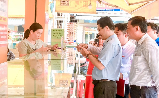 Lãnh đạo huyện Vĩnh Thuận trải nghiệm thanh toán không dùng tiền mặt bằng mã QR.