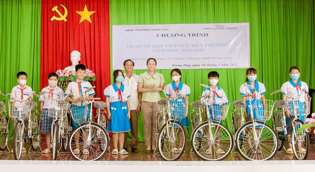 Đại diện lãnh đạo Ủy ban MTTQ phường Hưng Phú trao xe đạp cho các em học sinh.