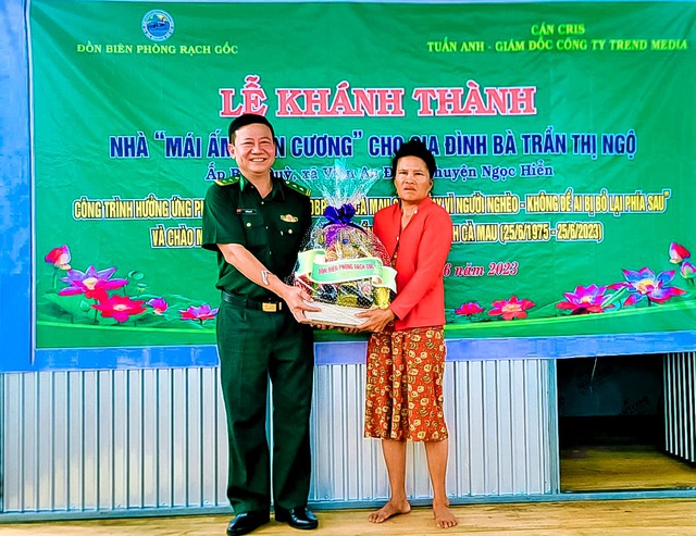 Trung tá Lê Văn Sử - Chính trị viên đồn Biên phòng Rạch gốc tặng quà cho bà Trần Thị Ngộ.