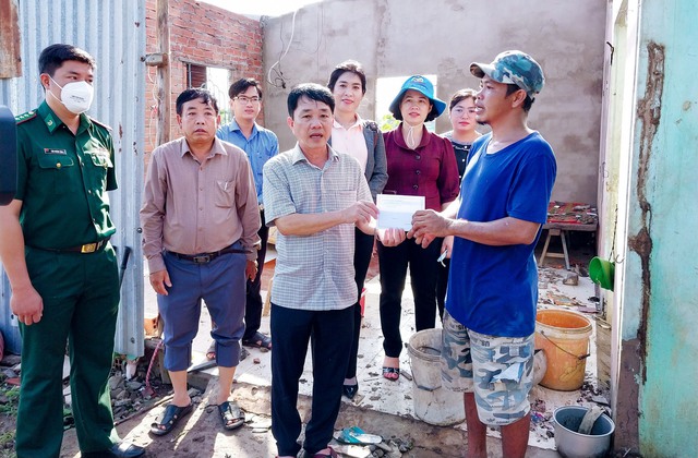 Ông Lưu Hữu Danh - Bí thư Huyện ủy Trần Đề trao tiền hỗ trợ cho các hộ dân bị thiệt hại nặng do thiên tai gây ra.