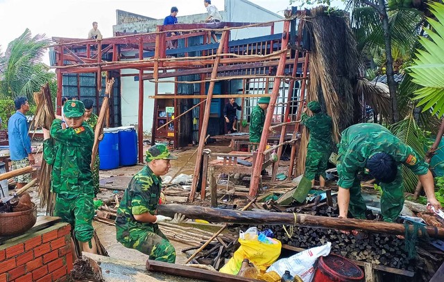 Cán bộ, chiến sĩ Đồn BP Khánh Hội cùng người dân địa phương dựng lại căn nhà bị sập do giông lốc gây ra.
