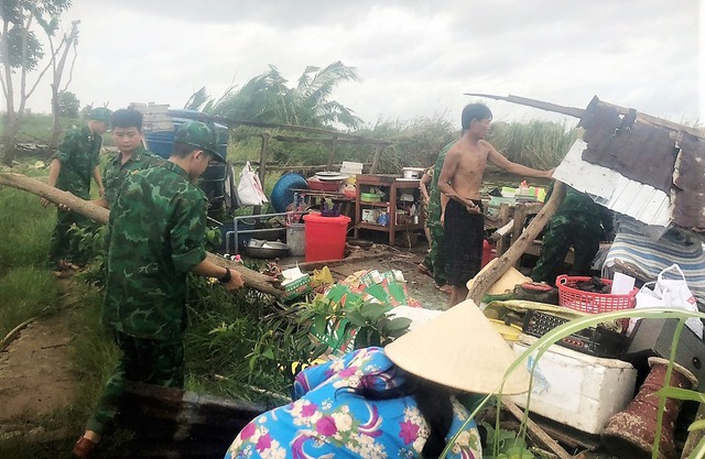 Cán bộ, chiến sĩ Đồn BP Khánh Hội giúp nhân dân dọn dẹp nhà cửa bị giông lốc làm sập.
