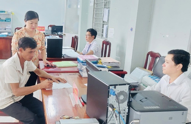 Anh Nguyễn Thanh Tuấn viết đơn xin thoát khỏi hộ nghèo tại Văn phòng UBND xã Bình Minh, huyện Vĩnh Thuận.
