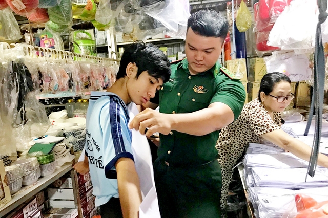 Cán bộ Đồn Biên phòng Vĩnh Nguơn mua đồng phục học sinh, dụng cụ học tập cho các em học sinh nhân dịp năm học mới 2023-2024.