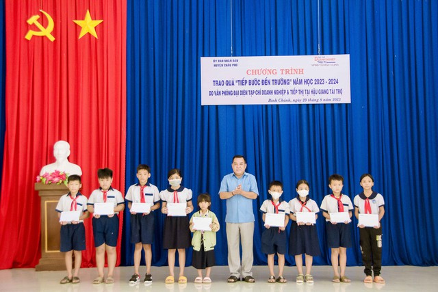 Ông Nguyễn Văn Bé Tám, Phó Chủ tịch UBND huyện Châu Phú trao học bổng cho các em học sinh.