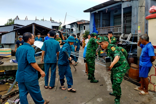 Cán bộ, chiến sĩ Đồn Biên phòng cửa khẩu Vĩnh Hội Đông giúp dân khắc phục hậu quả vụ dông lốc.