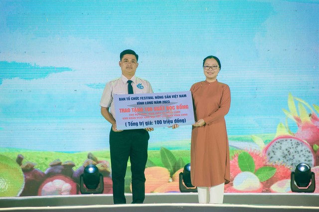 Bà Nguyễn Thị Quyên Thanh, Phó Chủ tịch UBND tỉnh Vĩnh Long trao bảng tượng trưng 100 suất học bổng cho đại diện Hội Sinh viên tỉnh Vĩnh Long.