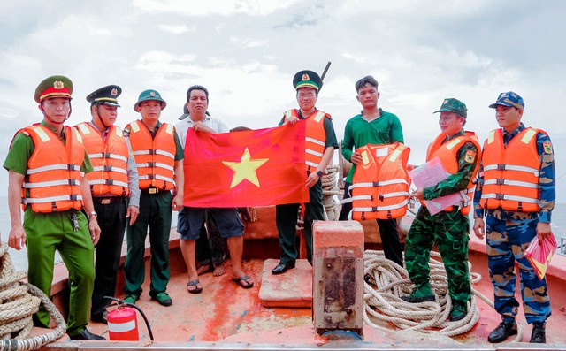 Tổ công tác tuyên truyền, tặng cờ tổ quốc và áo phao cho ngư dân.
