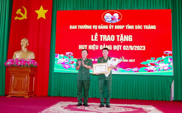 Đại tá Nguyễn Trìu Mến - Bí thư Đảng ủy, Chính ủy BĐBP tỉnh trao quyết định trao tặng huy hiệu 30 năm tuổi Đảng cho Đại tá Lê Văn Anh.
