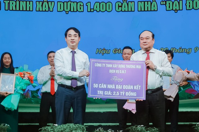 Bí thư Tỉnh ủy Hậu Giang Nghiêm Xuân Thành trao bảng tượng trưng 50 căn nhà &quot;Đại đoàn kết&quot; của Công ty TNHH xây dựng thương mại dịch vụ D.N.T cho UBMTTQ Việt Nam tỉnh Hậu Giang. Ảnh: Đài PTTH Hậu Giang