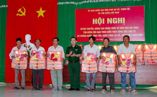Lãnh đạo BĐBP tỉnh Sóc Trăng tặng áo phao và cờ Tổ quốc cho các thuyền viên và chủ tàu trên địa bàn huyện Trần Đề.