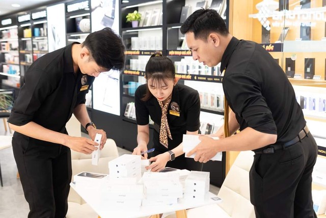 Nhân viên showroom Phương Tùng chuẩn bị dòng smartphone hot nhất hiện nay lên kệ trưng bày.